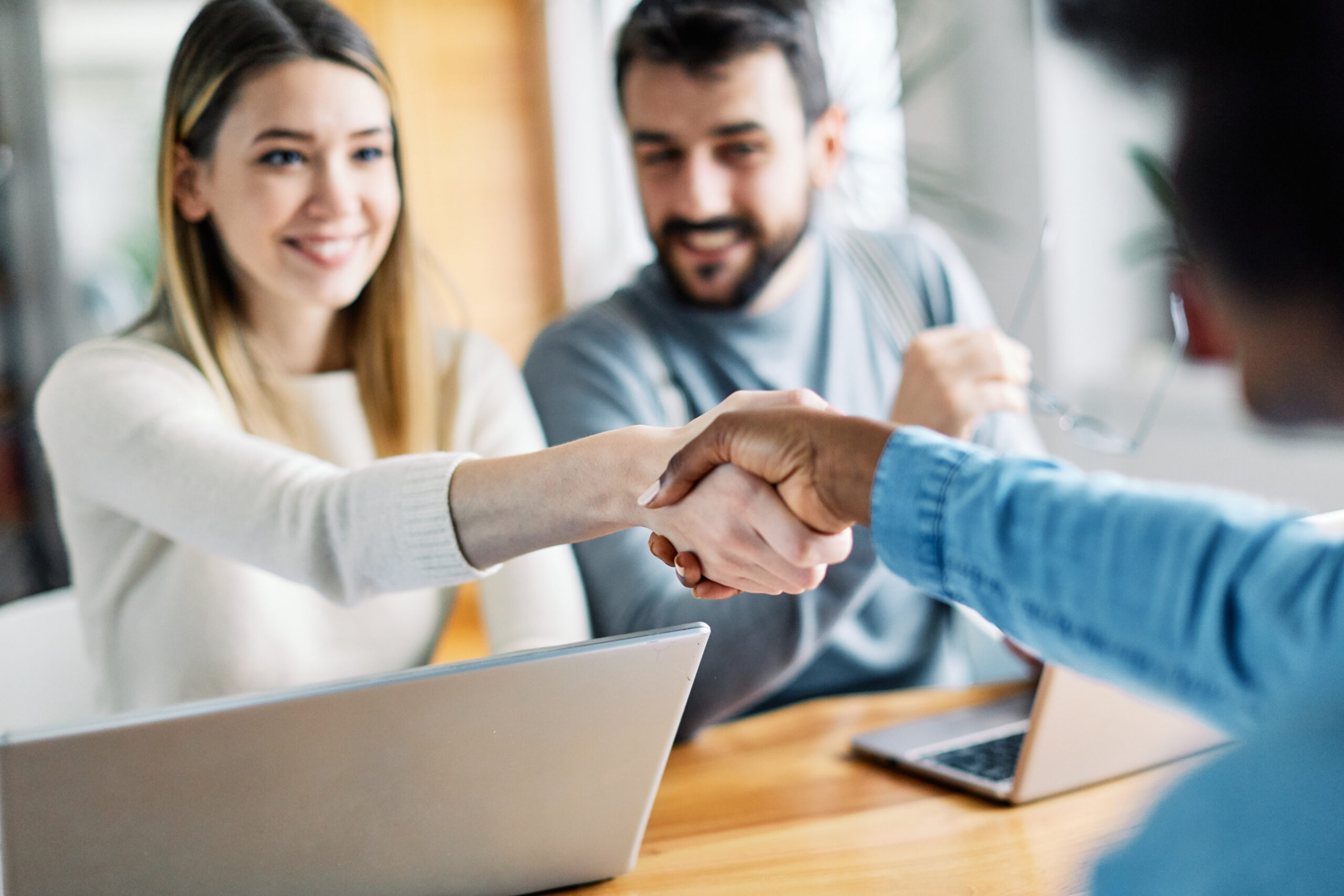 young couple shaking hands deal contract real estate investment Real estate agent with couple shaking hands closing a deal