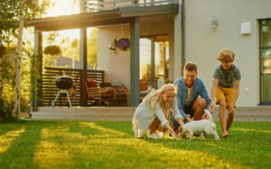 Family-Outside-of-Their-Home-Grilling-and-Playing-with-the-Dog